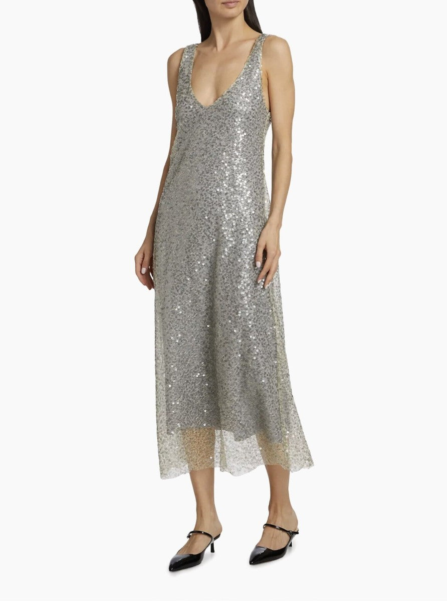 Woman wearing a silver sequin dress on a white background. Luxury for less