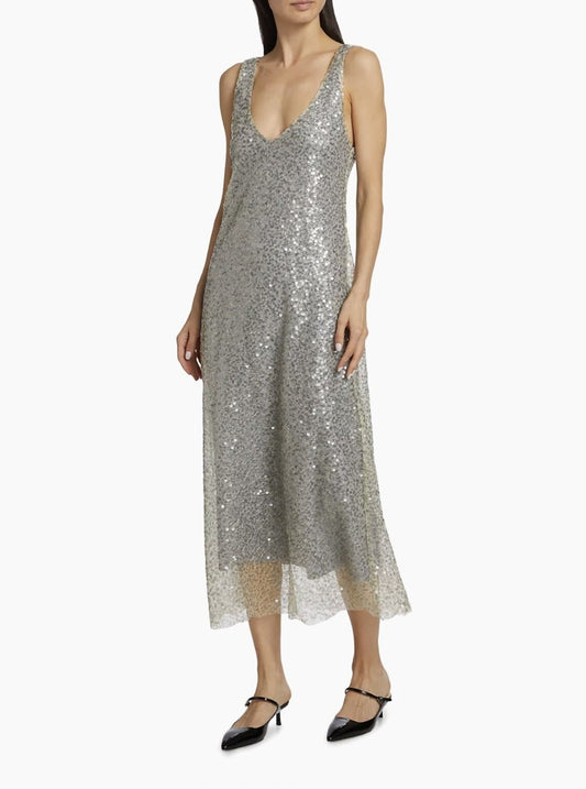 Woman wearing a silver sequin dress on a white background. Luxury for less