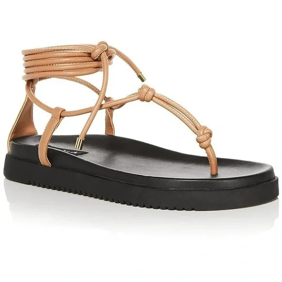 Beige sandal with black sole on a white background