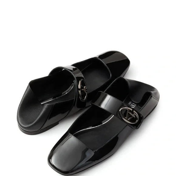 Pair of black glossy loafers with a brand logo on a white background. Luxury for less