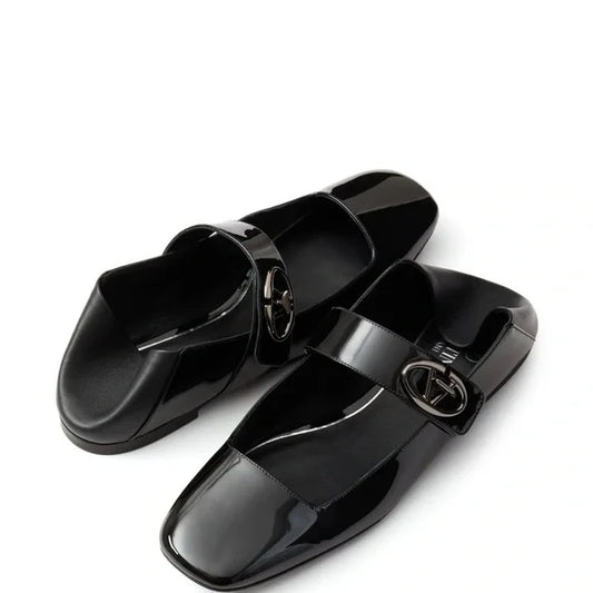 Pair of black glossy loafers with a brand logo on a white background. Luxury for less