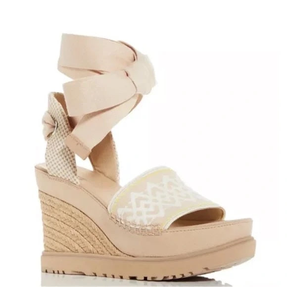 Beige wedge sandal with bow detail on a white background. Discounted