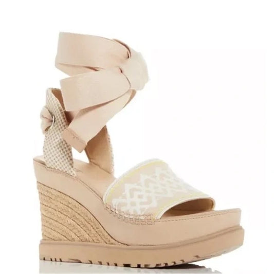 Beige wedge sandal with bow detail on a white background. Discounted